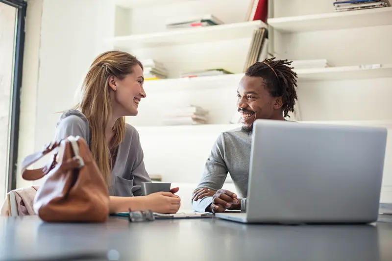 Two people talking across a desk